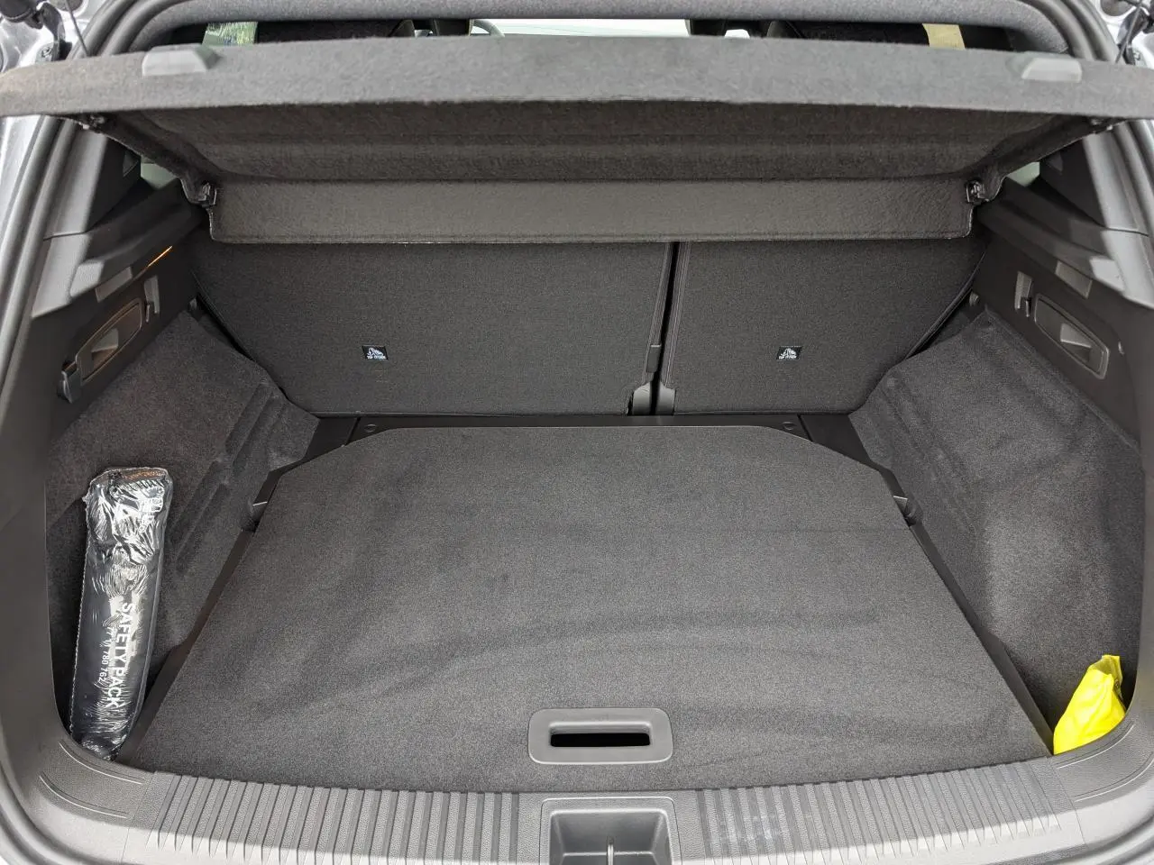 Coffre ouvert du Renault Austral gris, vue arrière montrant un espace de chargement propre et bien agencé.