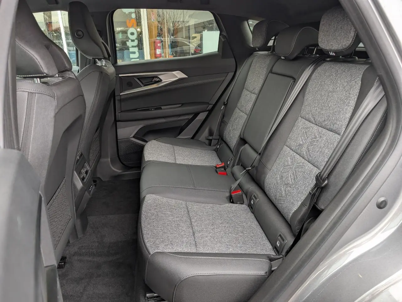 Vue latérale droite de la banquette arrière grise et noire du Renault Austral 2025 avec sellerie mixte textile embossée.