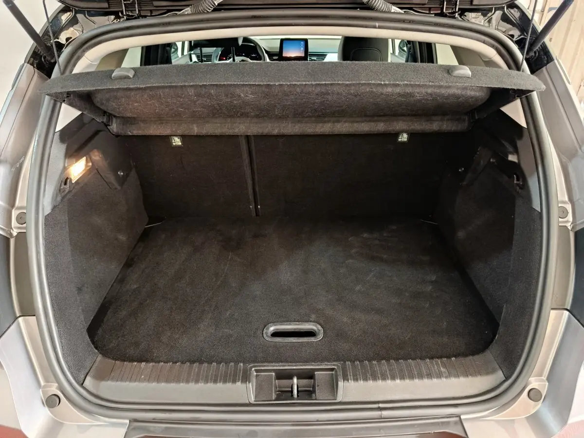 Coffre ouvert d’un Renault Captur gris foncé 2024, vue arrière montrant l’espace de chargement vide et la tablette cache-bagages.
