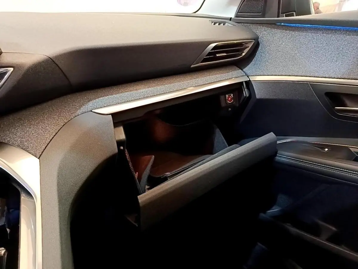 Intérieur Peugeot 3008 2022, vue côté passager, boîte à gants ouverte avec tableau de bord gris foncé et noir.