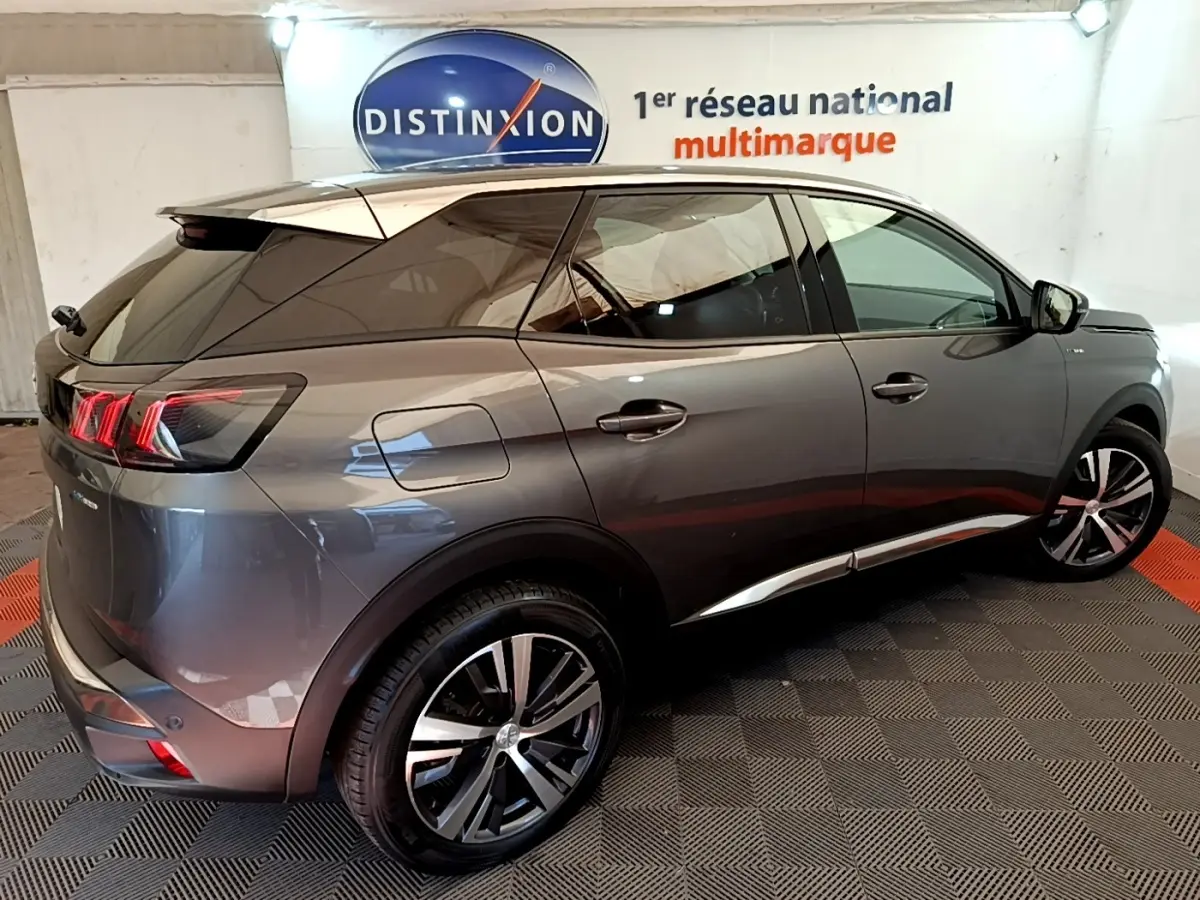 Vue 3/4 arrière droite d’un Peugeot 3008 gris foncé hybride rechargeable avec feux arrière LED et jantes alliage.