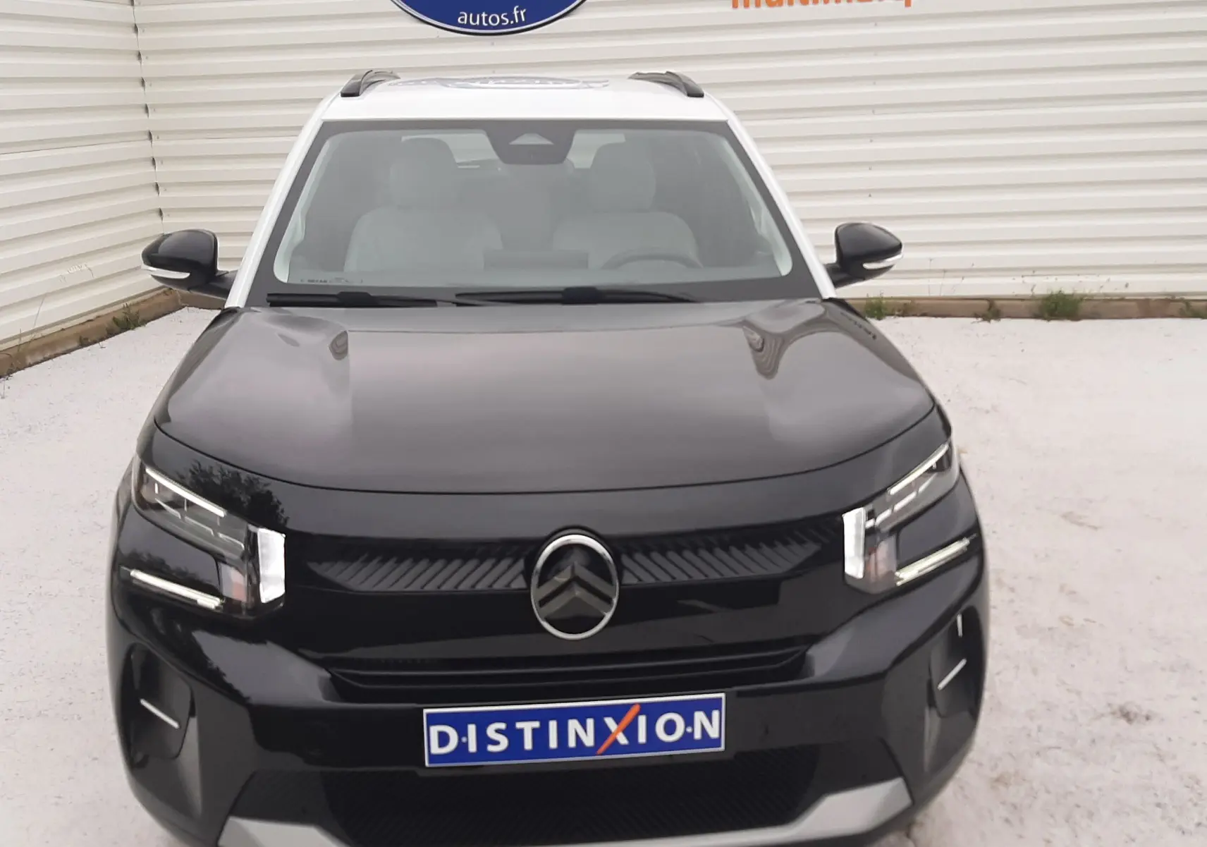Vue avant d'une Citroën C3 2025 noir perla avec toit blanc, mettant en valeur sa calandre et ses phares LED distinctifs.