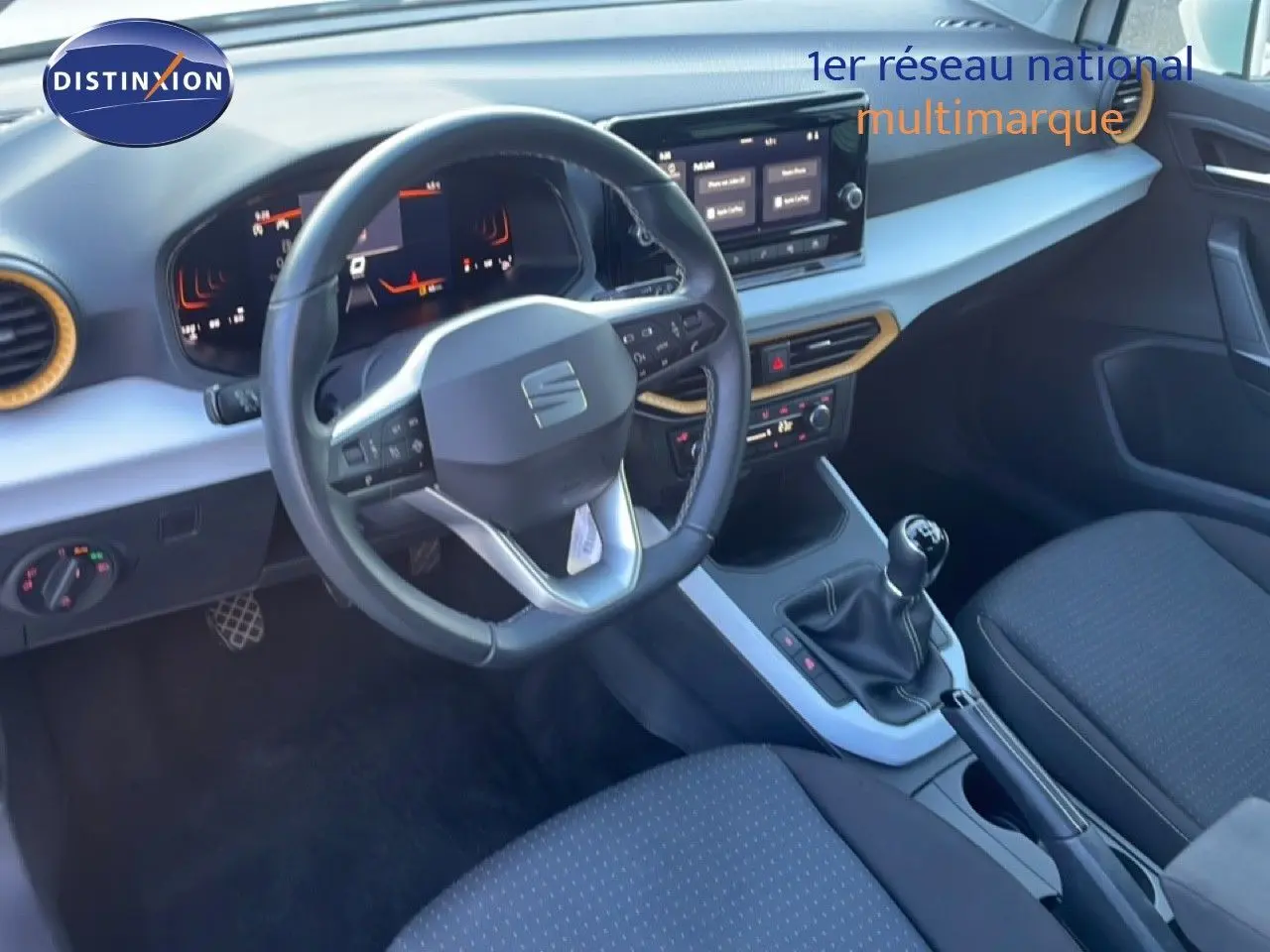 Intérieur du SEAT Arona 2025 vu côté conducteur, volant cuir multifonction, tableau de bord numérique et boîte manuelle.