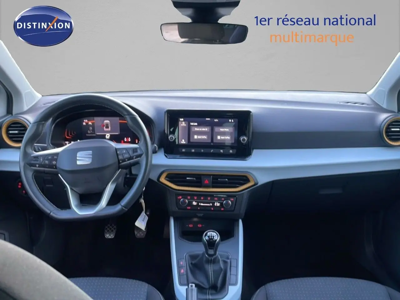 Intérieur avant du SEAT Arona blanc toit gris 2025, tableau de bord moderne avec écran tactile et volant multifonction.