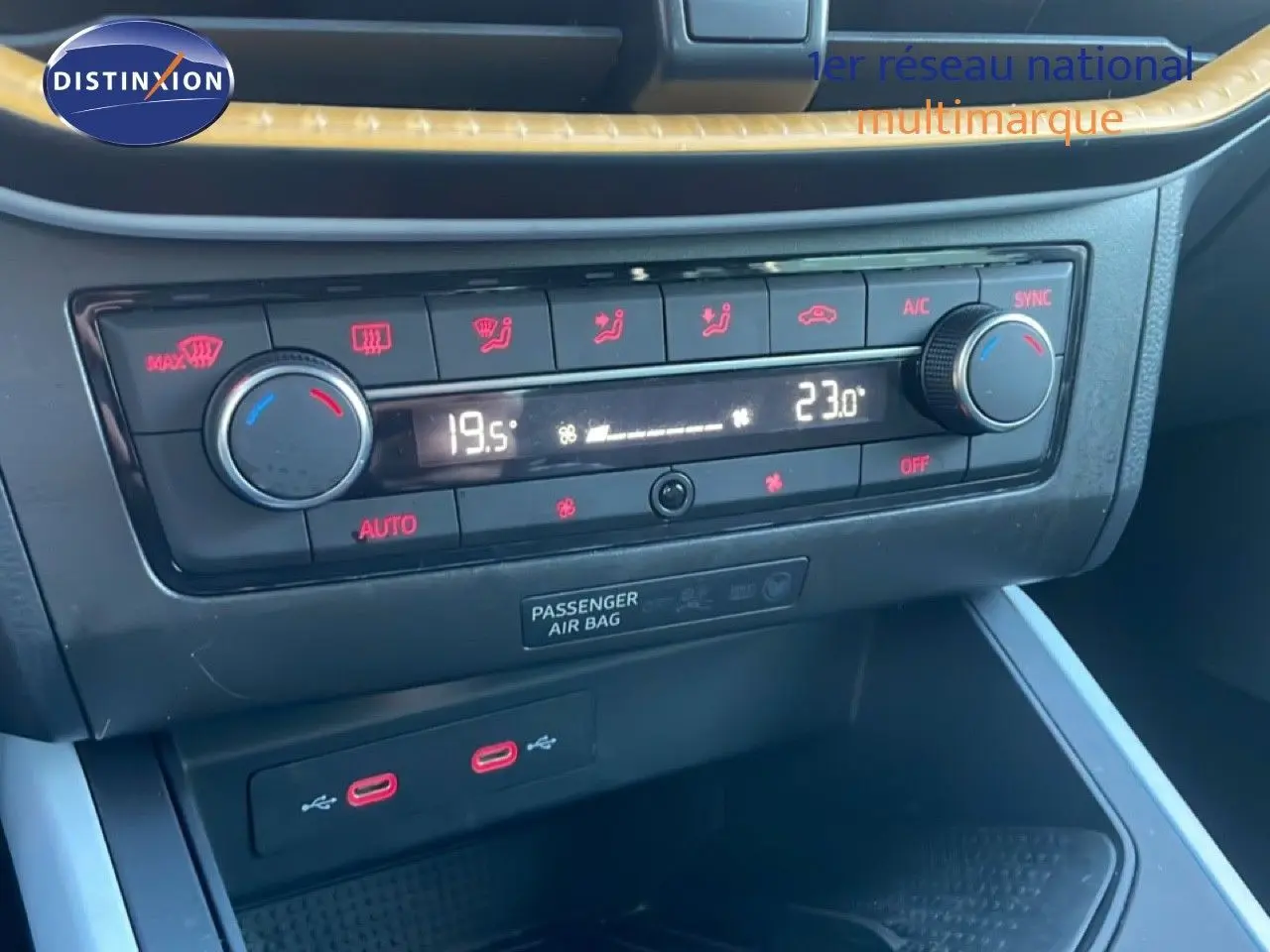 Gros plan sur la console centrale du SEAT Arona 2025, montrant la climatisation digitale et deux ports USB rouges.