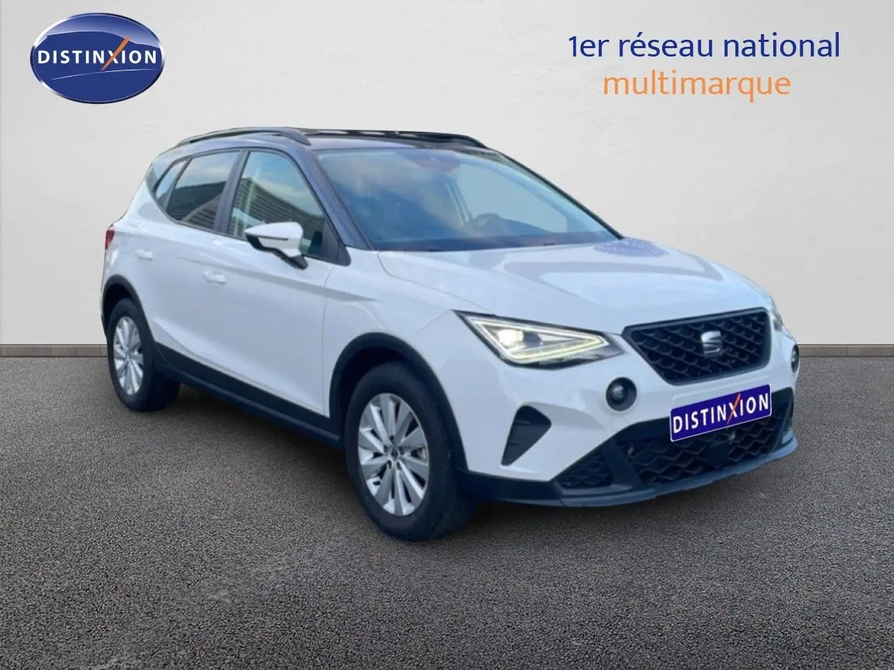 SEAT Arona blanc avec toit gris, vue 3/4 avant droit, phares allumés et calandre noire distinctive.