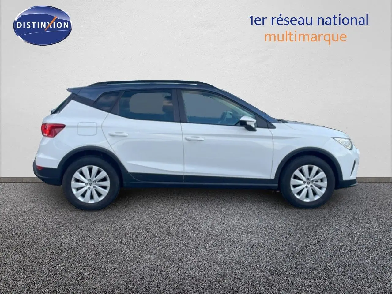 Vue de profil côté gauche d'un SEAT Arona blanc avec toit gris, roues alliage et détails noirs sur les bas de caisse.