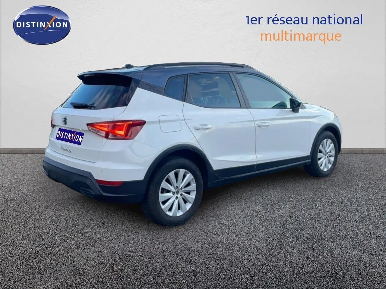 Vue 3/4 arrière côté droit d’un SEAT Arona blanc avec toit gris, jantes alliage et feux arrière LED.