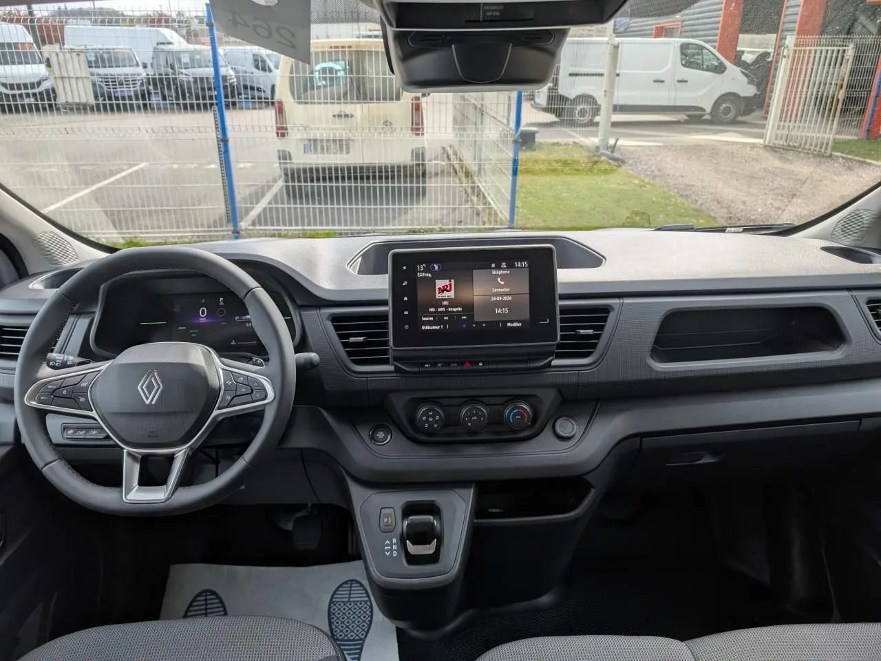Vue frontale de l'intérieur gris du Renault Trafic Fourgon 2025, avec tableau de bord numérique et écran tactile central.