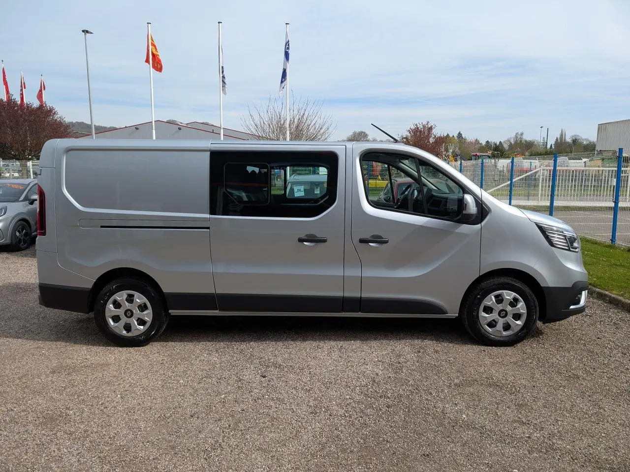 Renault Trafic Fourgon gris Highland vu de profil côté droit, avec portes coulissantes et enjoliveurs 16 pouces.