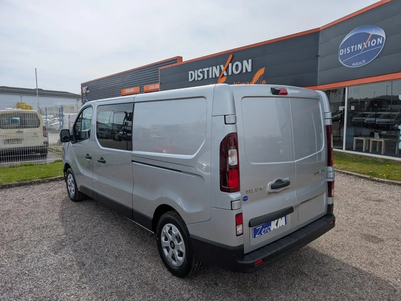 Vue 3/4 arrière droite d’un Renault Trafic Fourgon gris Highland avec portes arrière tôlées et enjoliveurs 16 pouces.