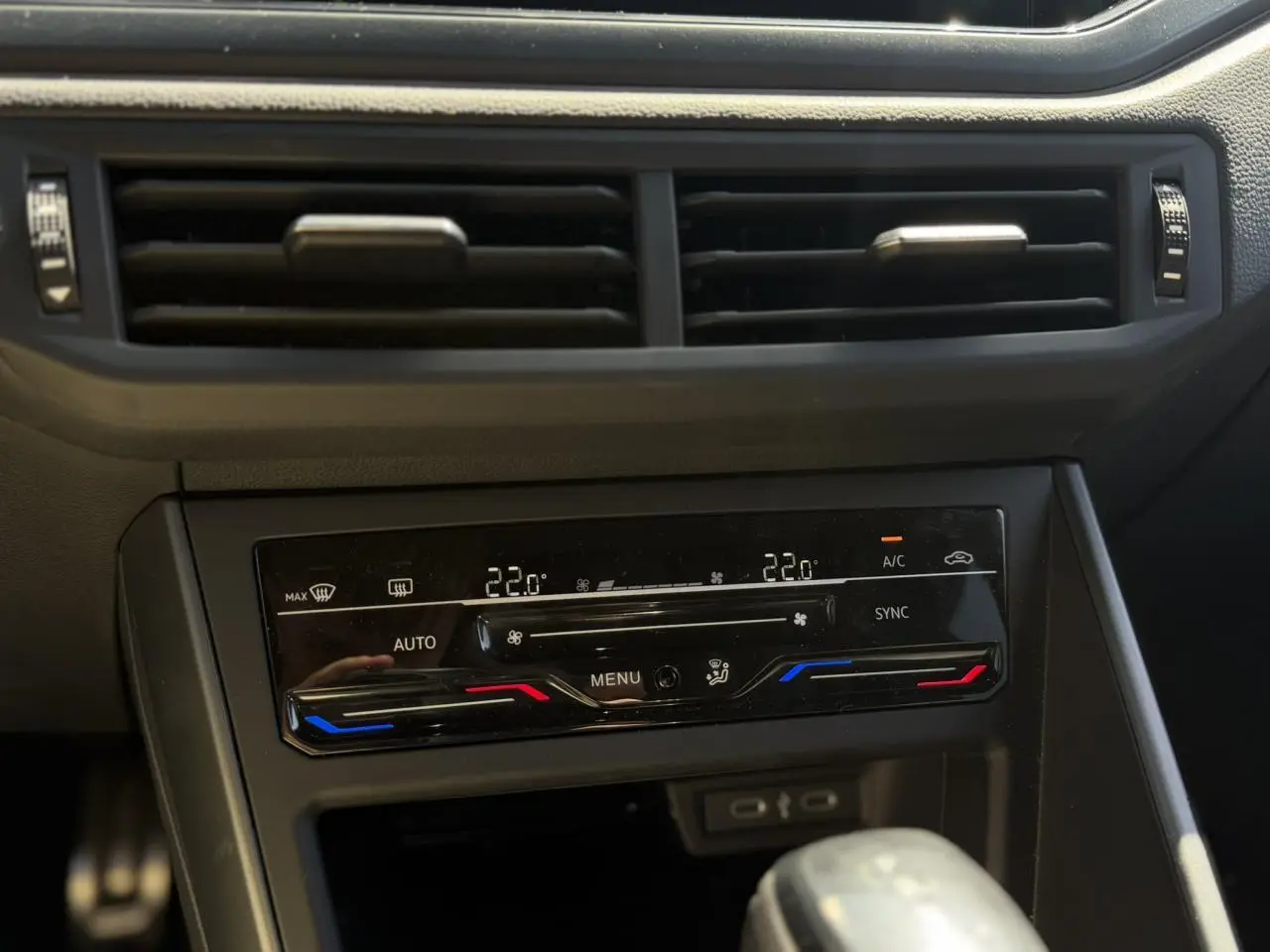 Vue rapprochée du tableau de bord du Volkswagen Taigo argent, mettant en valeur la climatisation automatique bi-zone et les commandes tactiles.