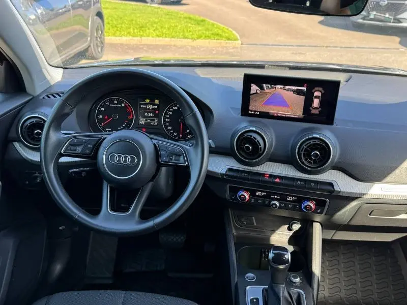Vue intérieure du tableau de bord de l'Audi Q2 35 TFSI 2023 avec écran de recul et volant multifonction noir.