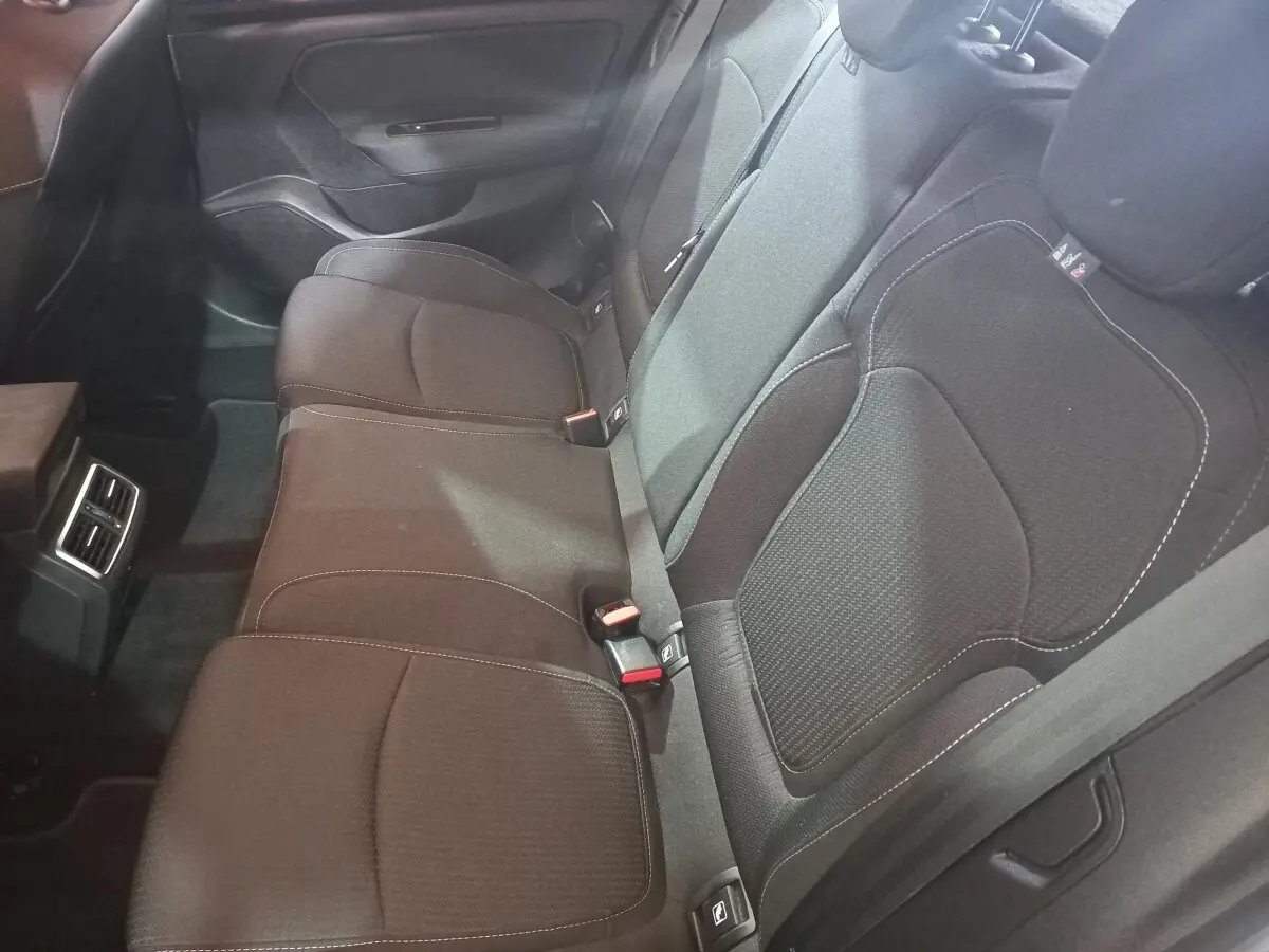 Vue intérieure de la banquette arrière grise foncée de la Renault Mégane Business TCe 115, avec ceintures et aérateurs centraux.