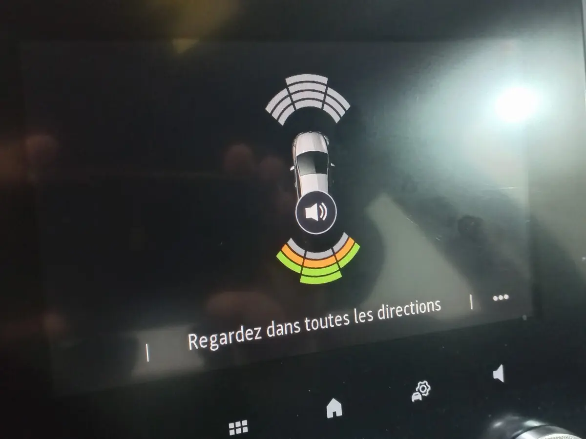 Affichage tactile intérieur montrant vue aérienne et capteurs de proximité d’une Renault Mégane gris foncé.