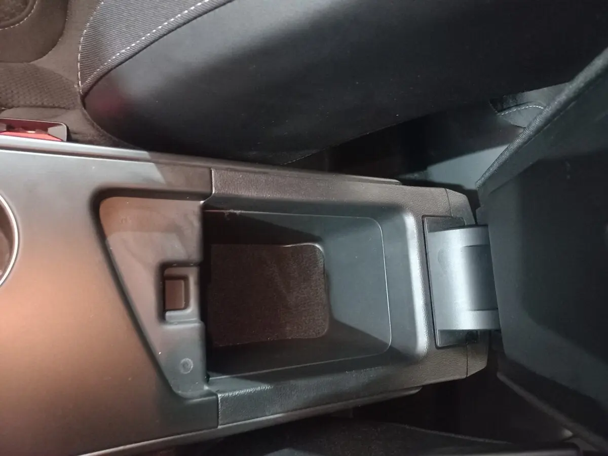 Gros plan sur le rangement central ouvert de la Renault Mégane Business TCe 115 gris foncé, intérieur noir.