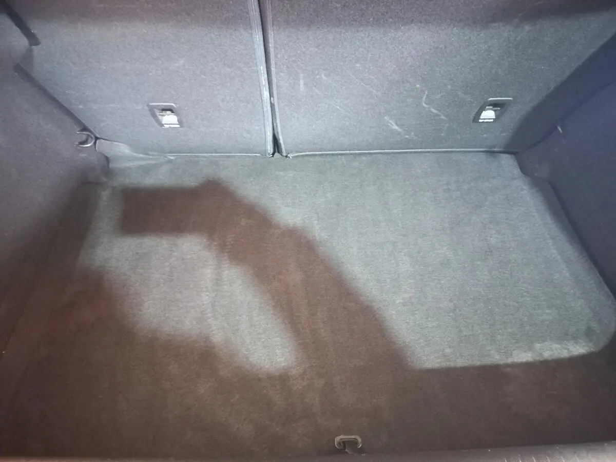 Coffre spacieux gris foncé de la Renault Mégane Business TCe 115 vu de dessus, avec banquette arrière rabattable.