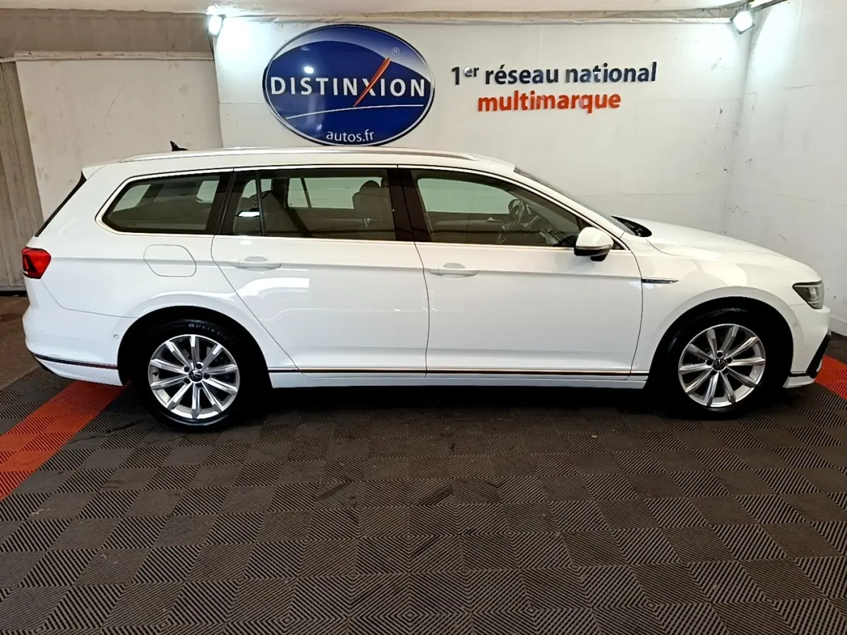 Volkswagen Passat 1.4 TSI hybride blanche vue de profil côté droit, break avec jantes alliage et toit ouvrant.