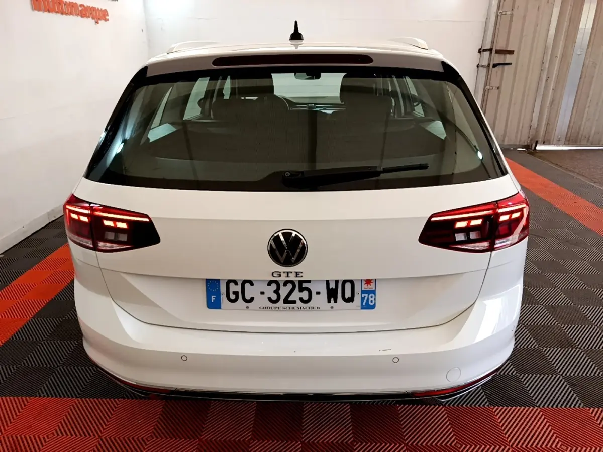 Vue arrière d'une Volkswagen Passat GTE blanche avec feux LED allumés et plaques d'immatriculation françaises.