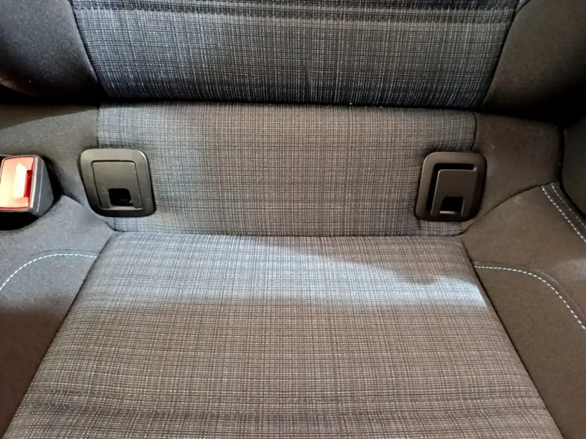 Gros plan sur la banquette arrière grise à motifs de la Volkswagen Passat hybride rechargeable, avec attaches ISOFIX visibles.
