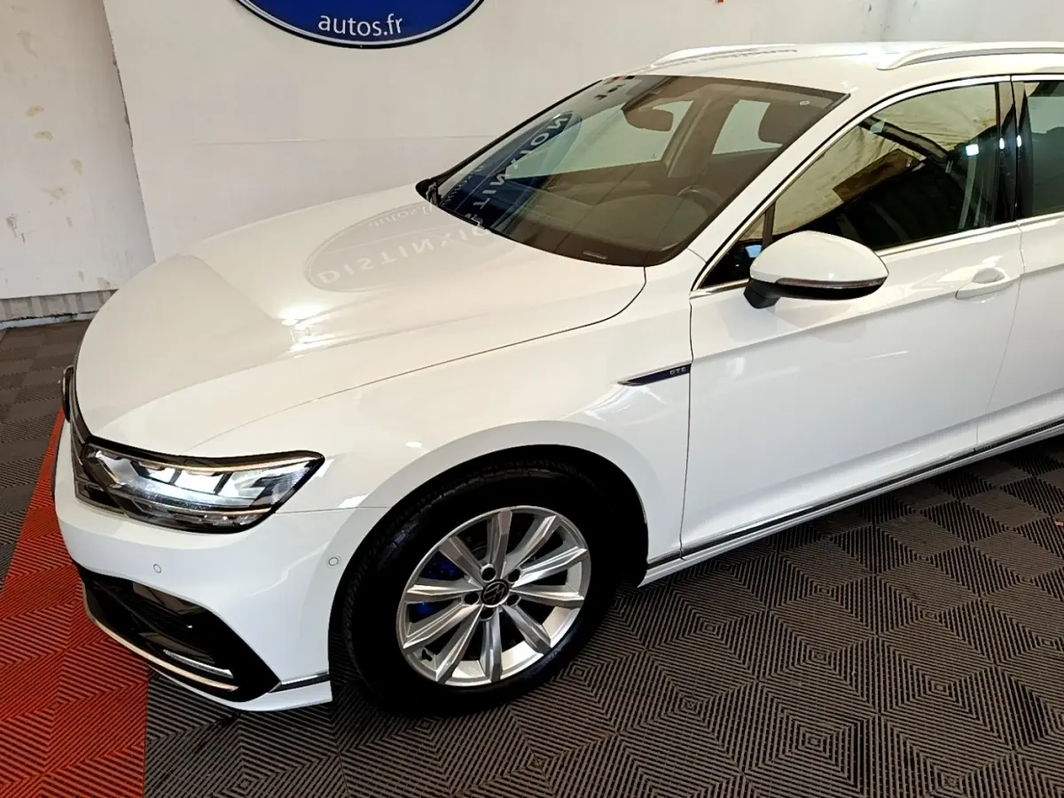 Vue 3/4 avant droite d'une Volkswagen Passat blanche hybride rechargeable avec jantes alliage et badge GTE sur aile.