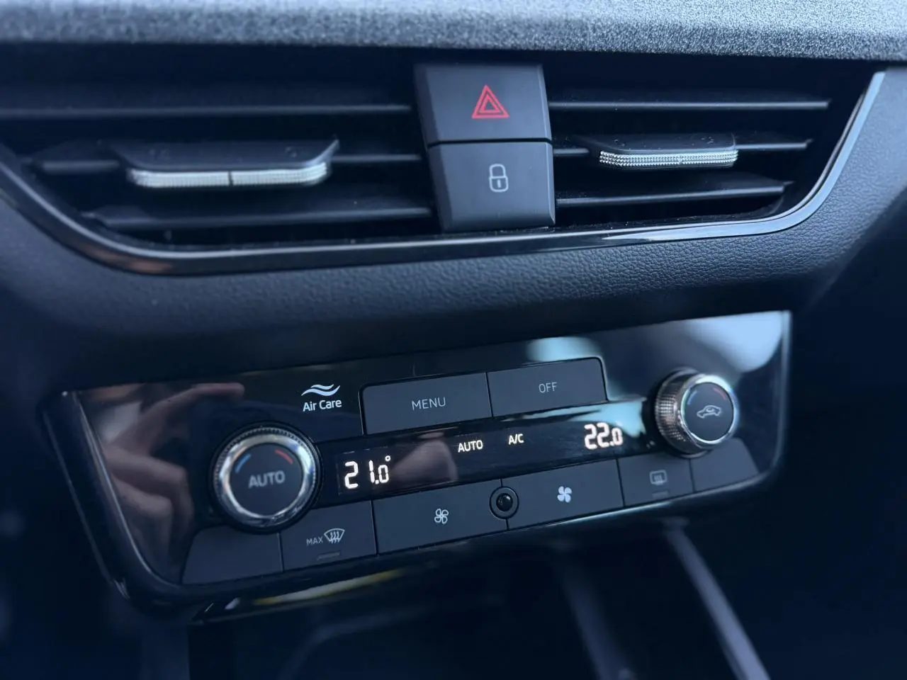 Gros plan sur la console centrale de la Skoda Scala TSI 116, affichant la climatisation automatique bi-zone avec réglages numériques.