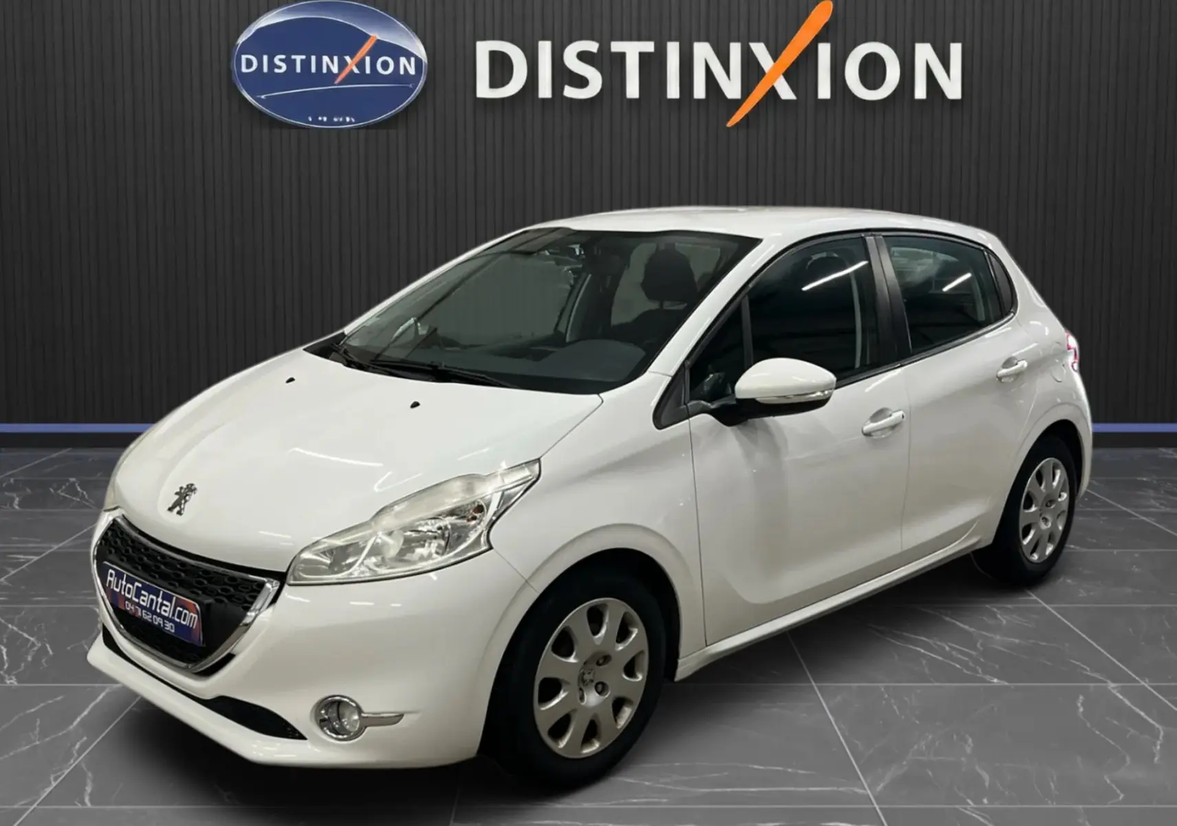 Peugeot 208 blanc vue 3/4 avant droit dans un showroom avec logo Distinxion en arrière-plan.