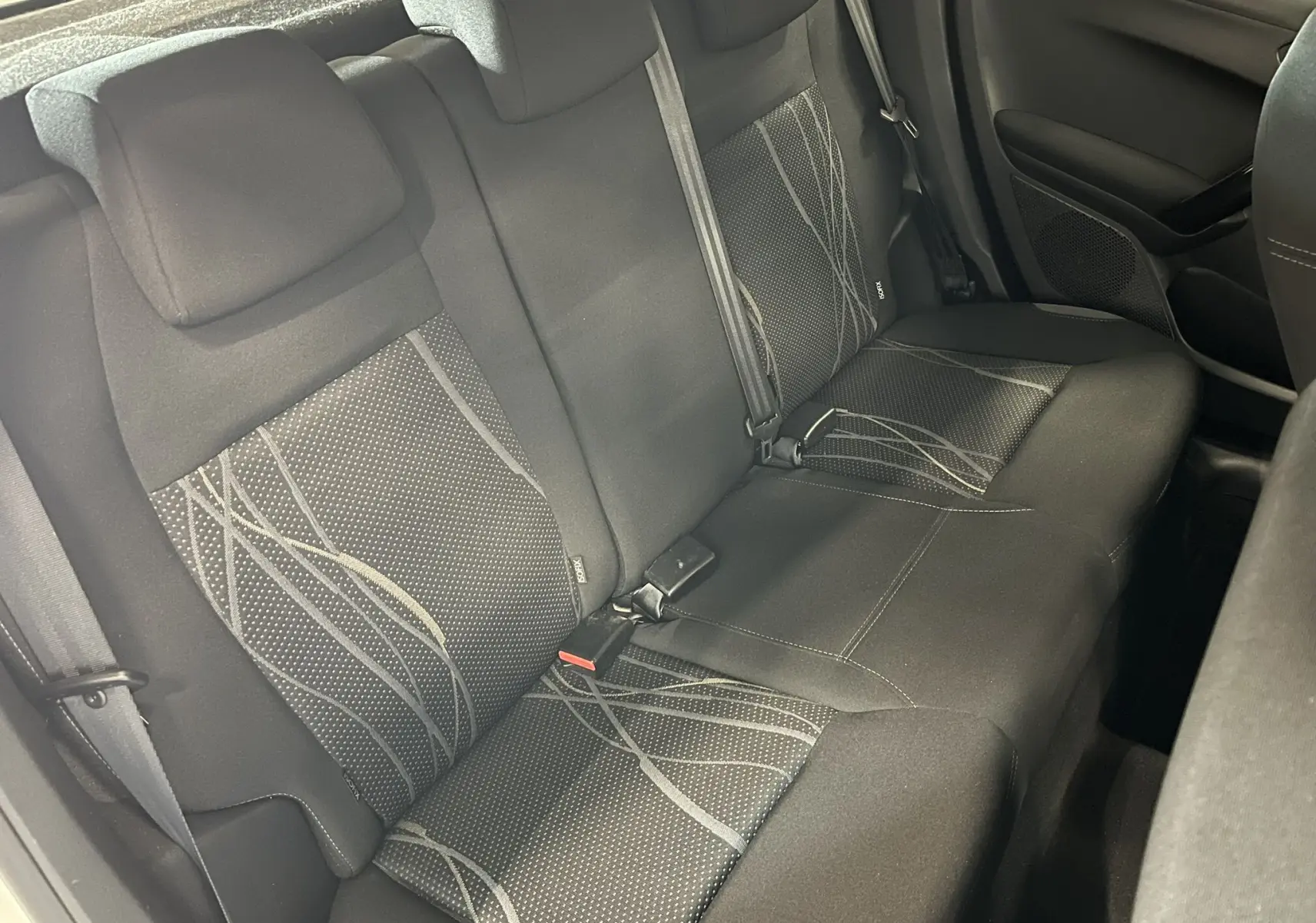 Vue intérieure des sièges arrière noirs avec motifs gris de la Peugeot 208 1.6 E-HDI Active 2014.