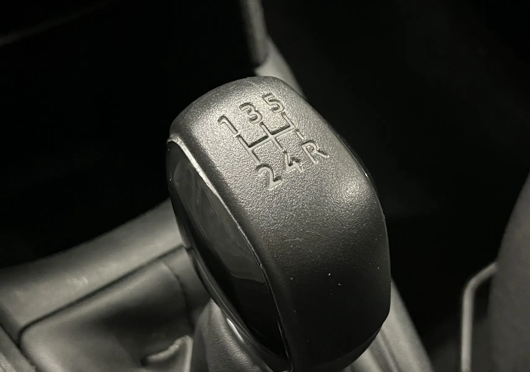 Le levier de vitesses manuel noir en gros plan de la Peugeot 208 1.6 E-HDI Active 2014.