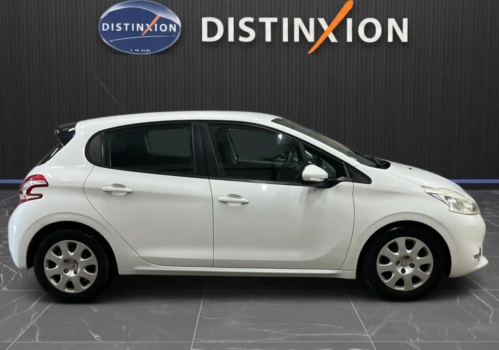 Profil droit d'une Peugeot 208 blanche 5 portes de 2014, avec jantes acier et rétroviseurs blancs, sur fond noir.