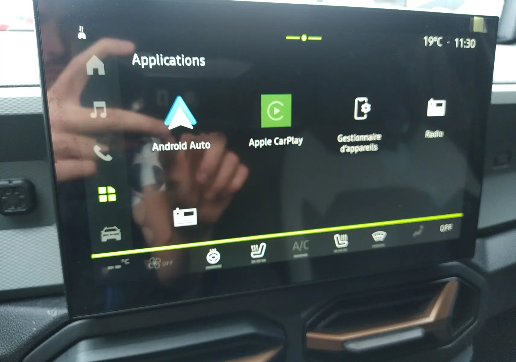 Écran tactile central du Dacia Duster Hybrid-G 150 ch en gros plan, affichant les applications Android Auto et Apple CarPlay.