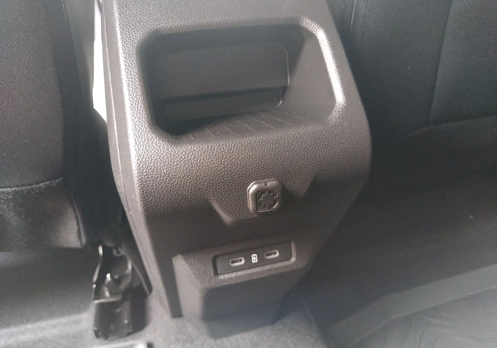 Détail de la console arrière noire du Dacia Duster Hybrid-G 150 ch, avec prises USB-C visibles en bas.