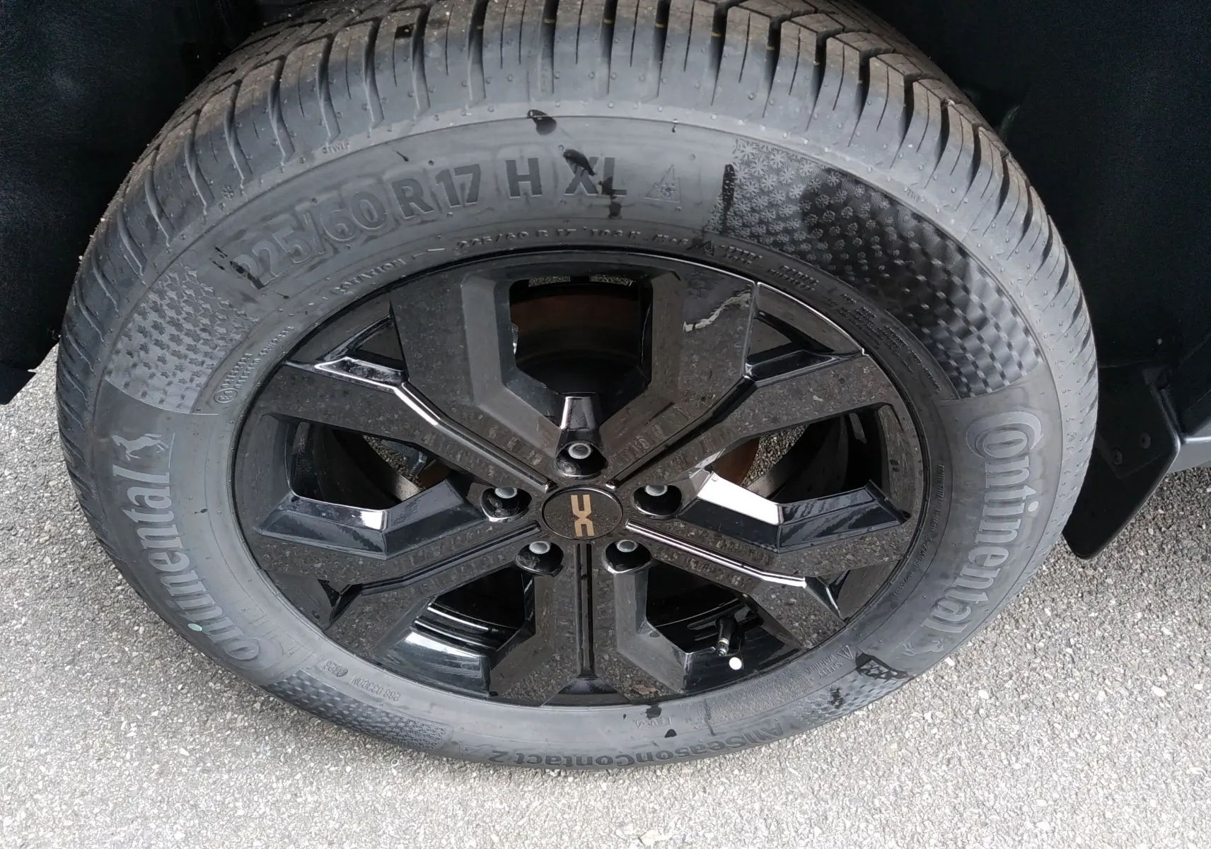 Gros plan sur la roue avant droite du Dacia Duster Hybrid-G 150 ch, jante noire brillante avec pneu Continental.