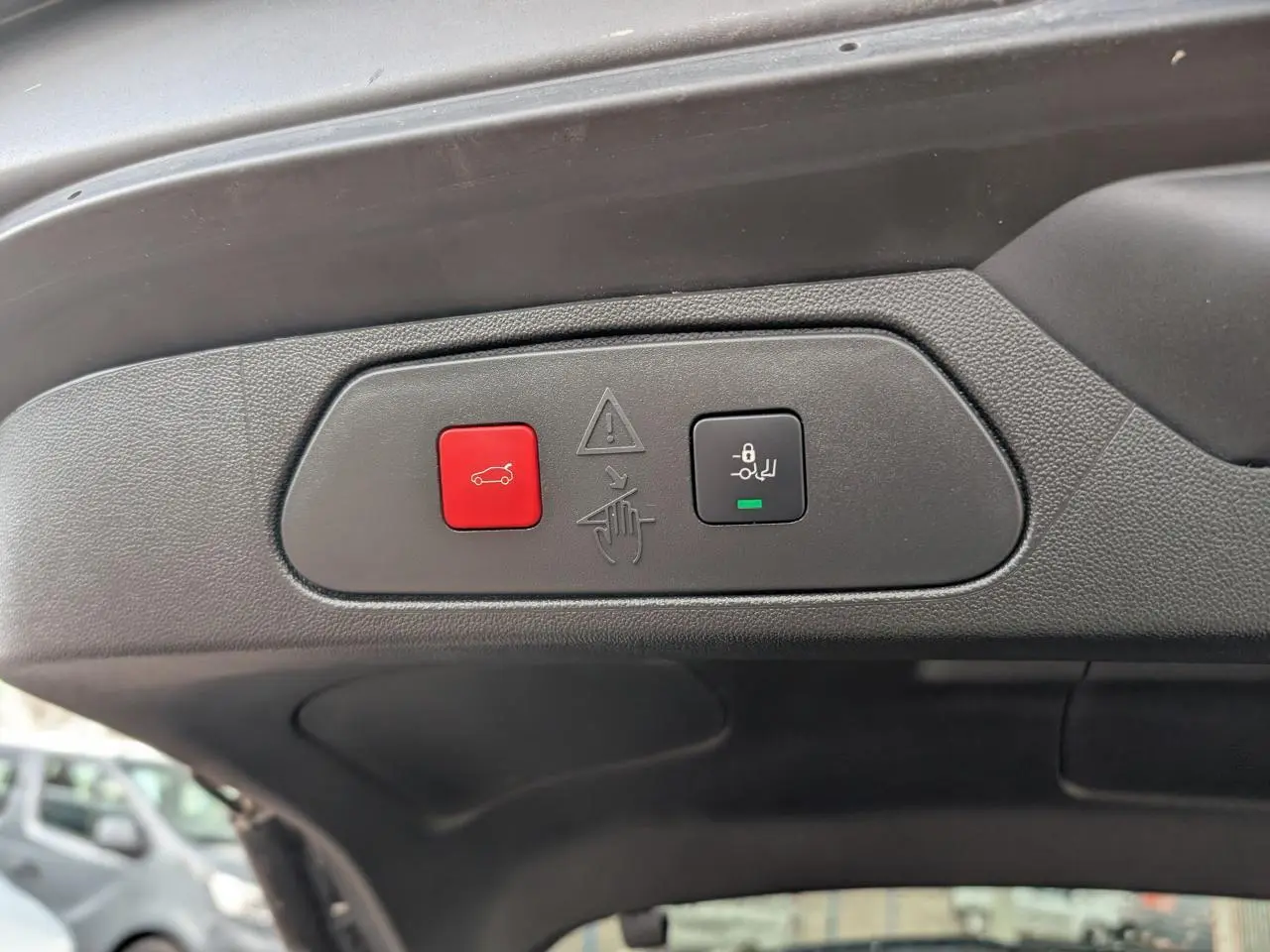 Gros plan sur les boutons de hayon motorisé avec ouverture mains-libres du coffre du Opel Grandland blanc métallisé.