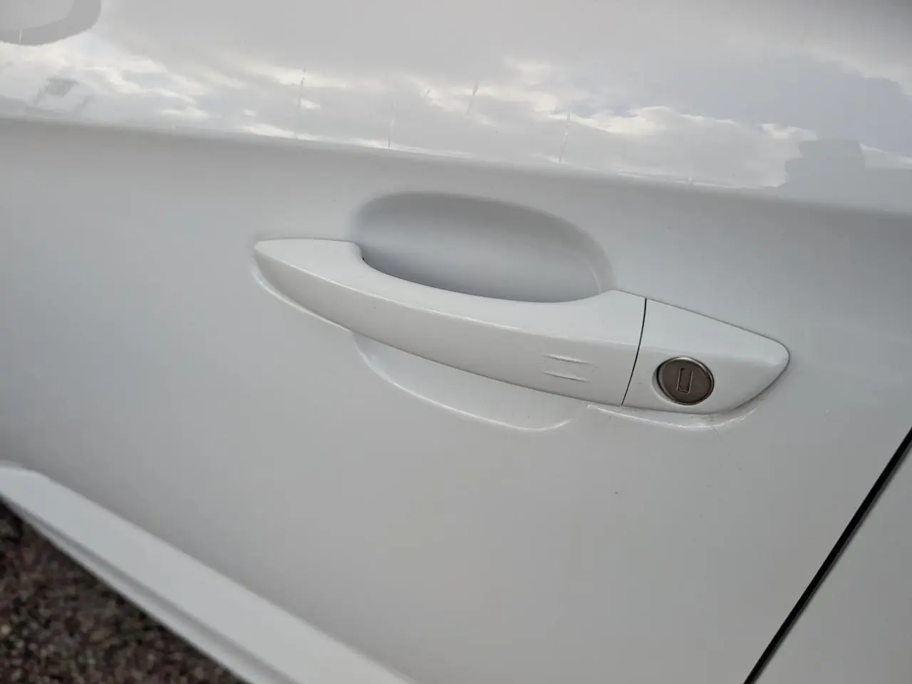 Poignée de porte blanche métallisée côté gauche de l'Opel Grandland 2024 avec serrure intégrée.