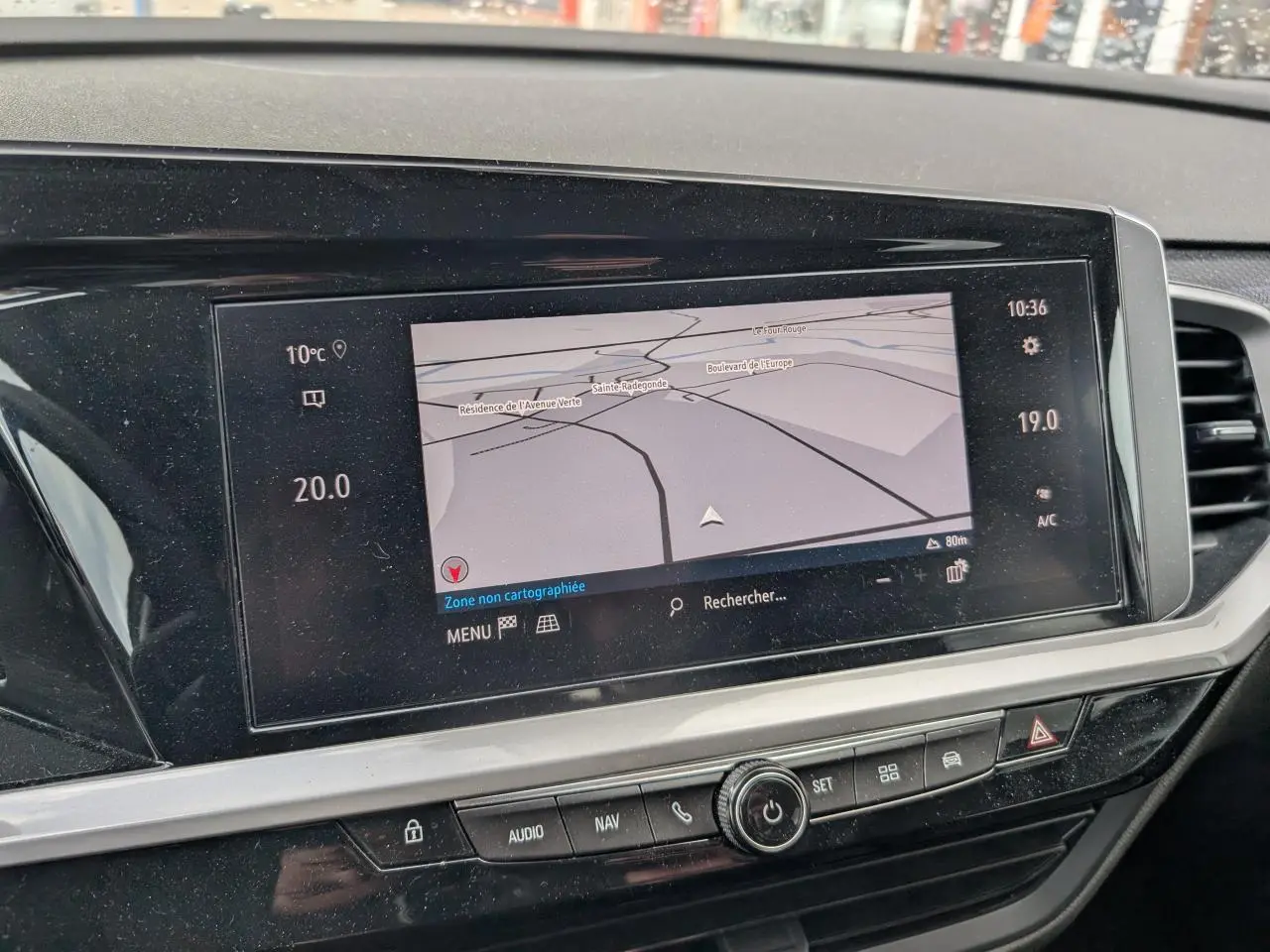 Vue intérieure centrée sur l'écran tactile du système de navigation du tableau de bord de l'Opel Grandland blanc.