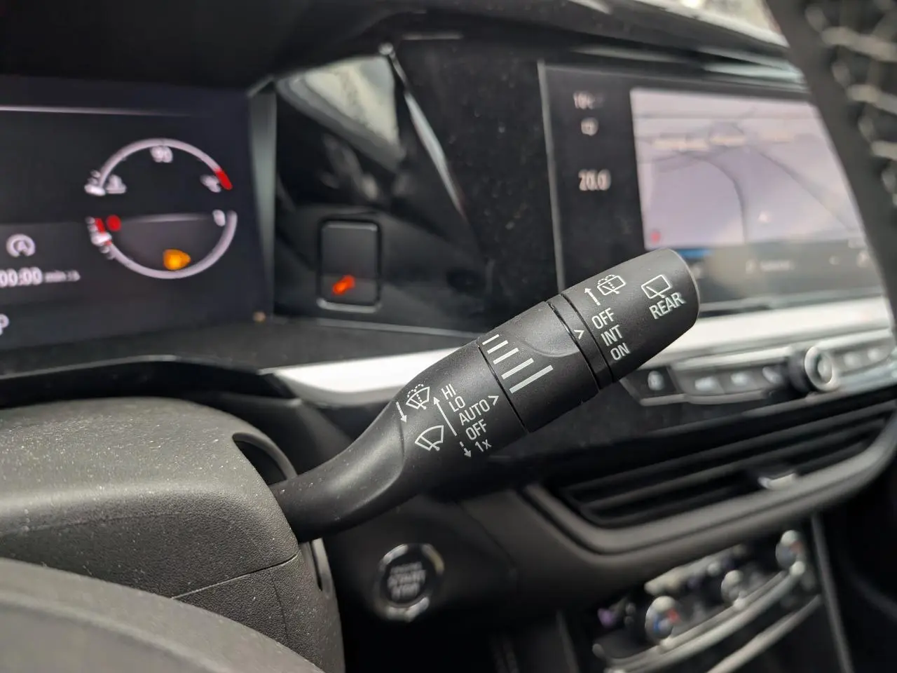 Gros plan sur la commande des essuie-glaces à gauche du volant dans l’habitacle d’un Opel Grandland blanc 2024.