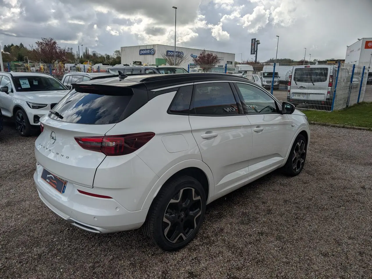 Opel Grandland blanc métallisé vue 3/4 arrière droit avec toit noir et jantes alliage noires 19 pouces.
