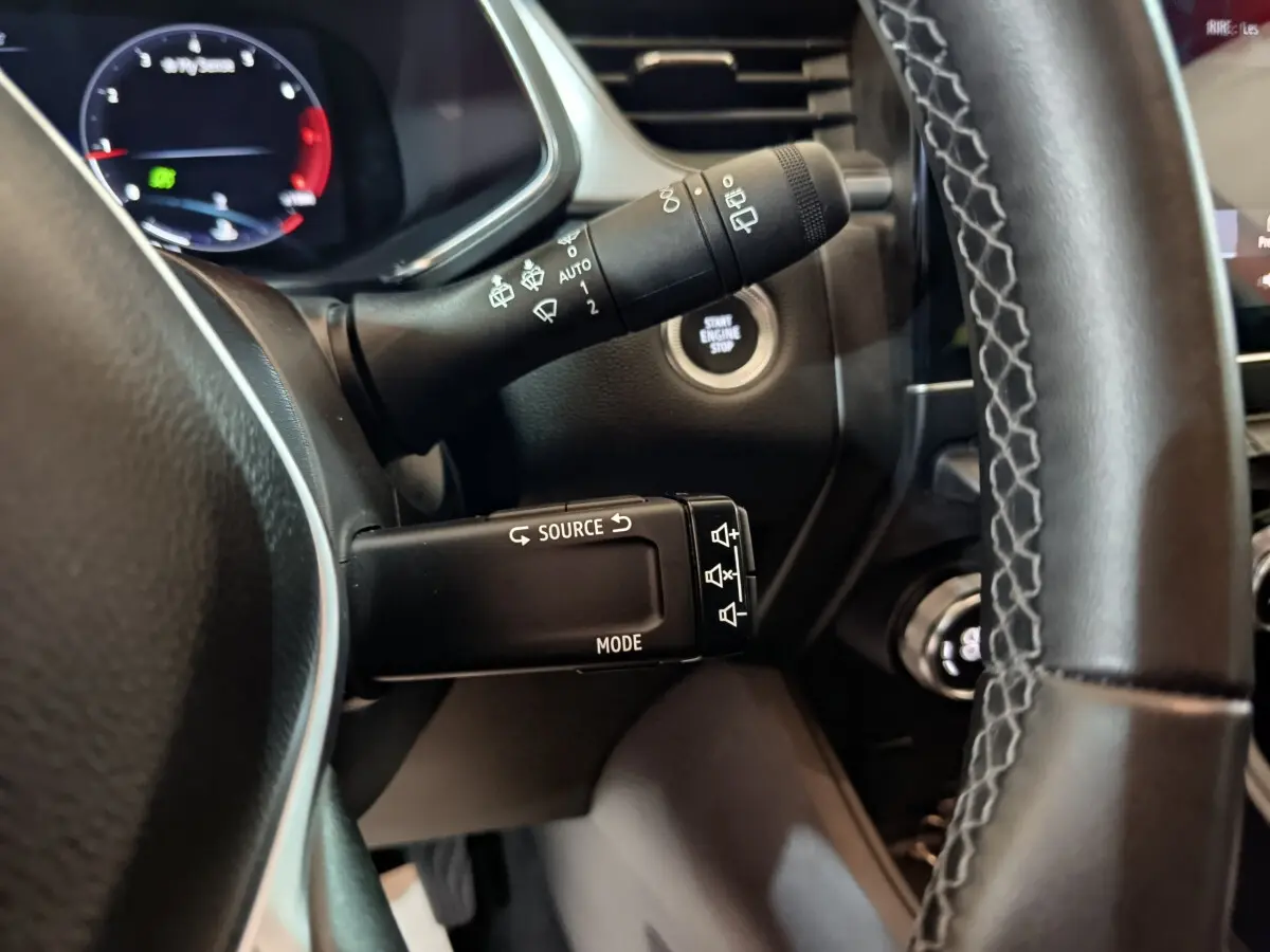 Gros plan sur la commande multifonctions et le bouton démarrage du tableau de bord du Renault Captur rouge 2024.