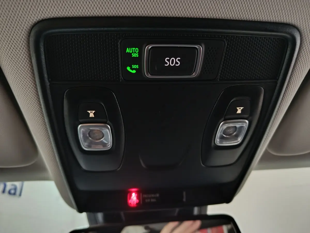 Détail du plafonnier intérieur avec bouton SOS et éclairages de lecture du Renault Captur rouge 2024.