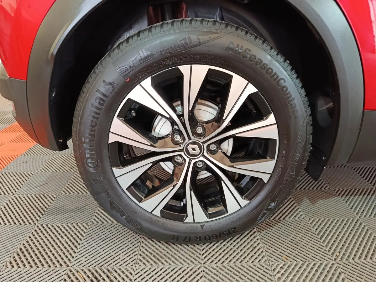 Gros plan sur la roue avant droite du Renault Captur rouge 2024 avec jante alliage bicolore et pneu Continental.