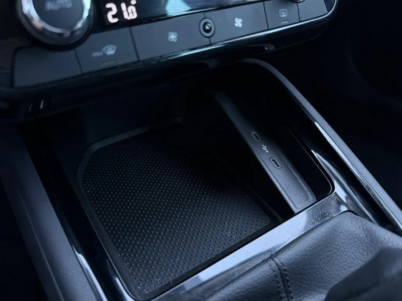 Gros plan sur la console centrale noire de la Skoda Scala TSI 116, montrant les ports USB-C et le rangement antidérapant.