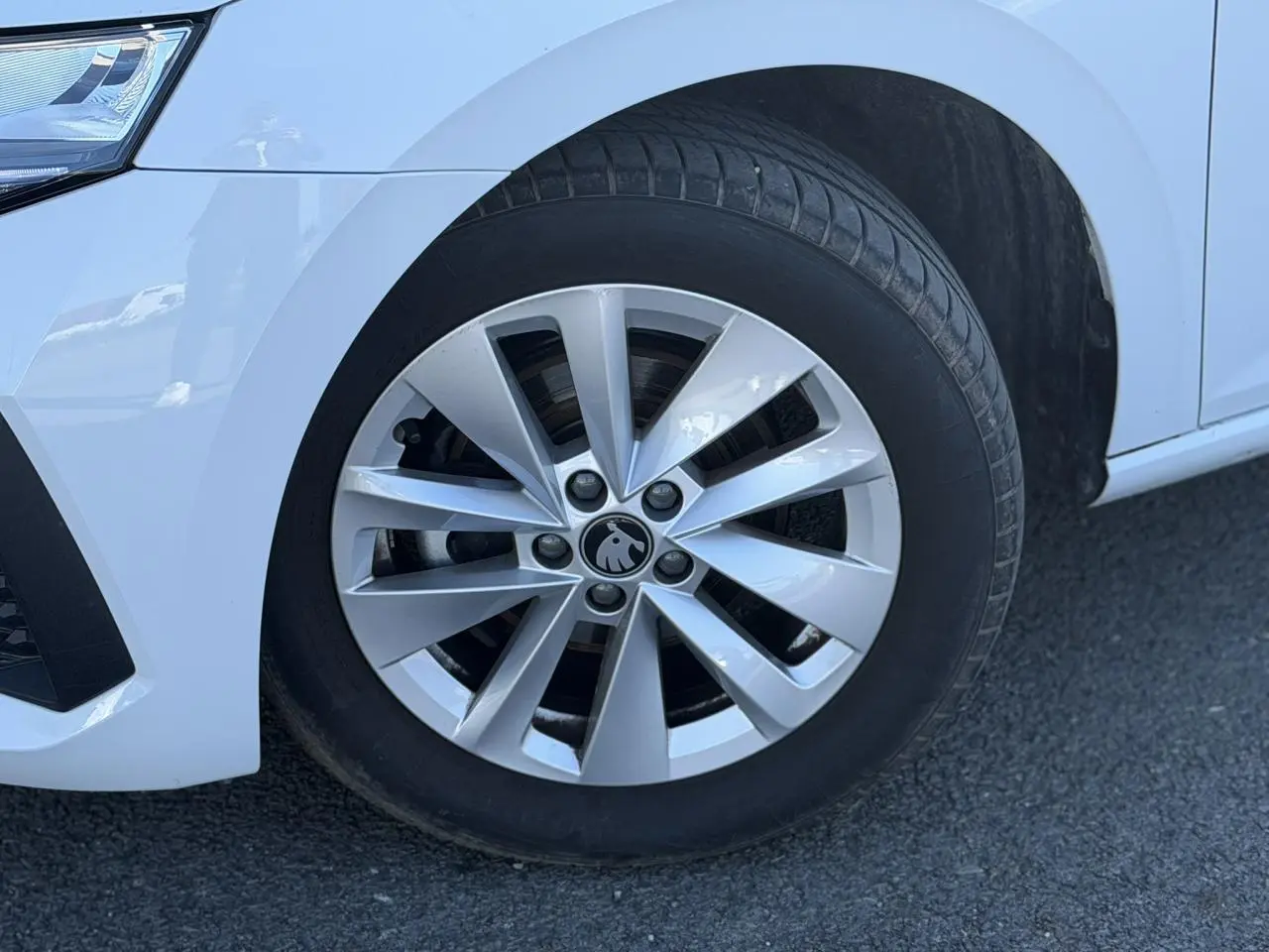 Gros plan sur la roue avant gauche d’une Skoda Scala blanche Glacier avec jante alliage 16 pouces Cortadero Aero.