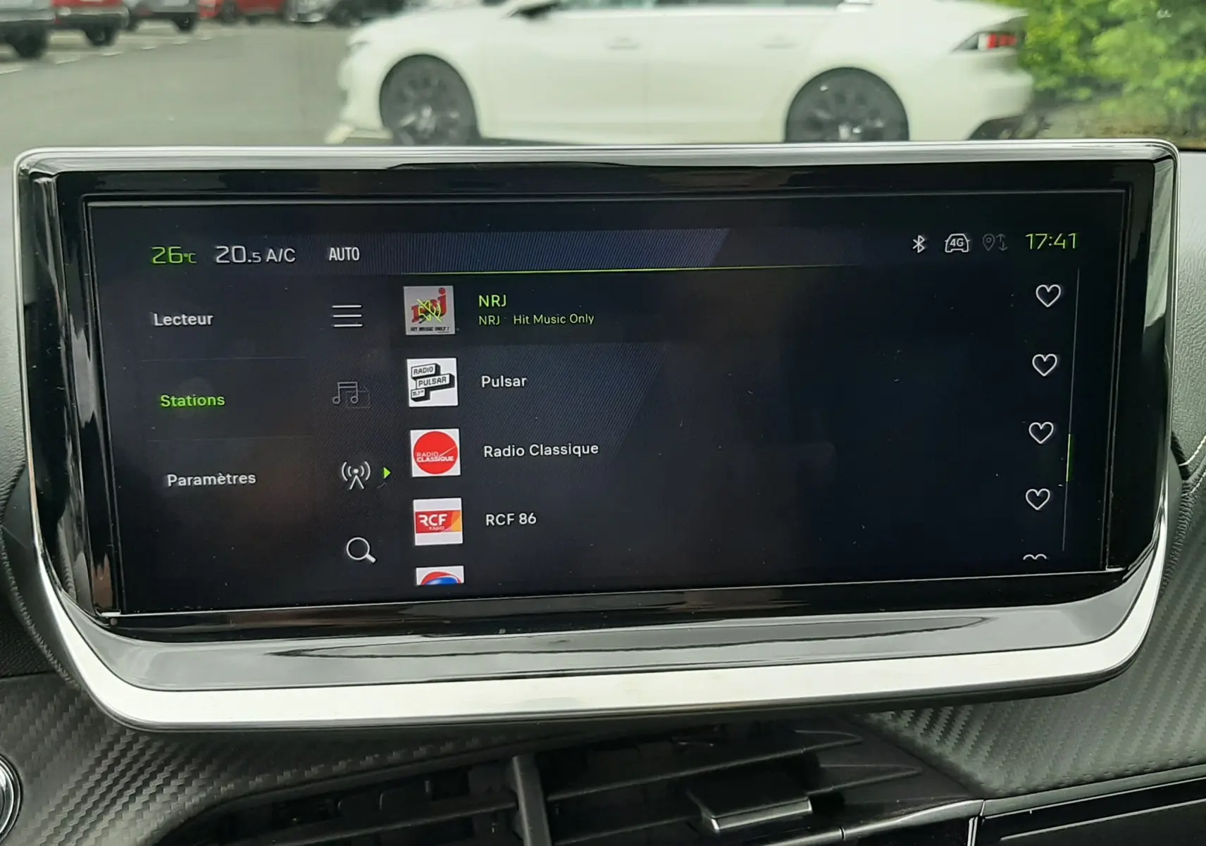 Vue intérieure sur l'écran multimédia de la Peugeot 208 1.2 100CH GT avec tableau de bord noir et extérieur gris Artense visible.
