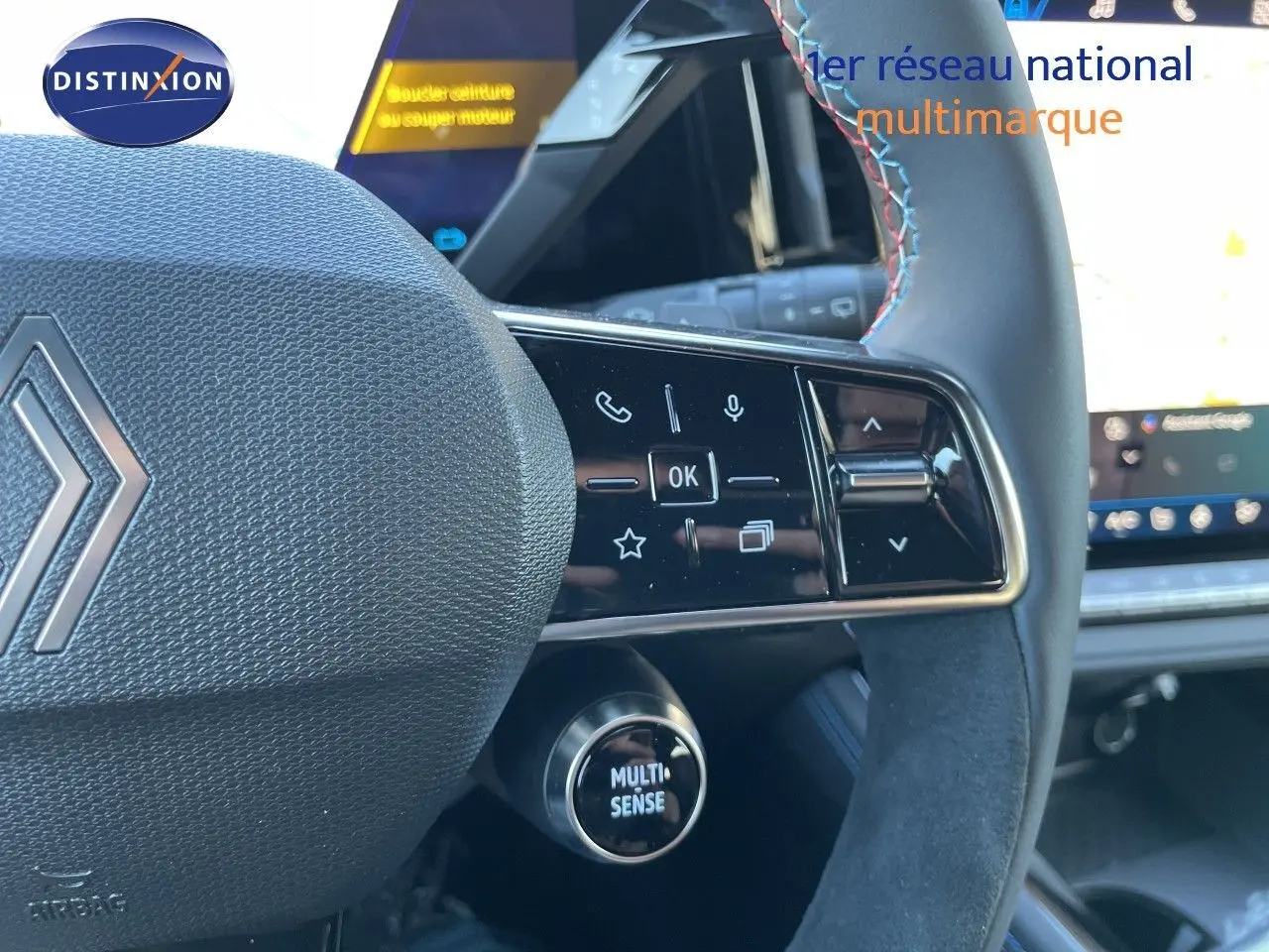 Gros plan sur le volant noir du Renault Austral E-Tech 2026, avec commandes tactiles et bouton Multi-Sense visible.