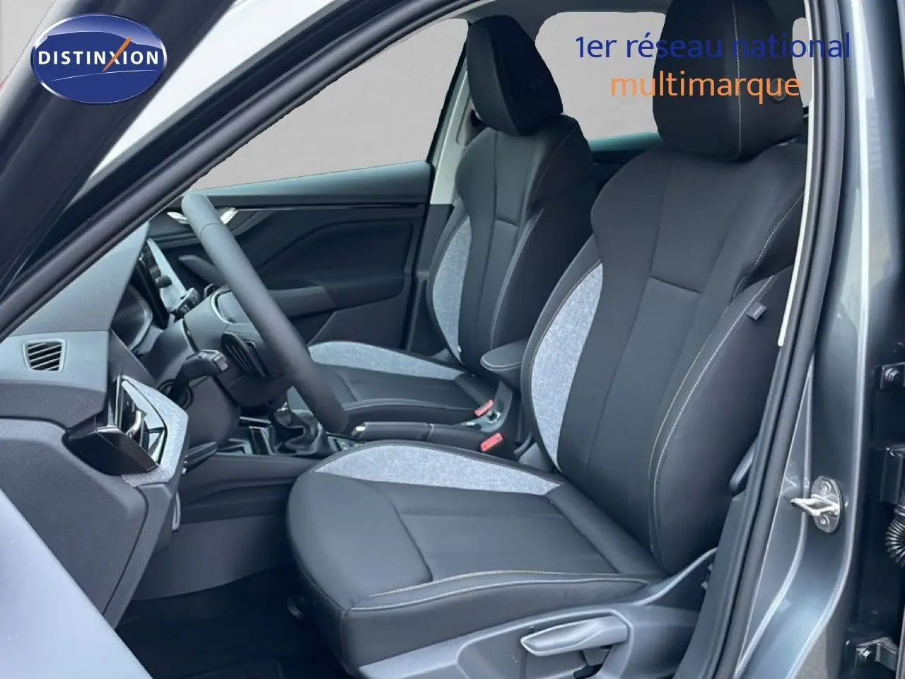 Vue intérieure côté gauche du Skoda Kamiq gris graphite métal 2025, mettant en valeur les sièges avant bi-matière noir et gris.