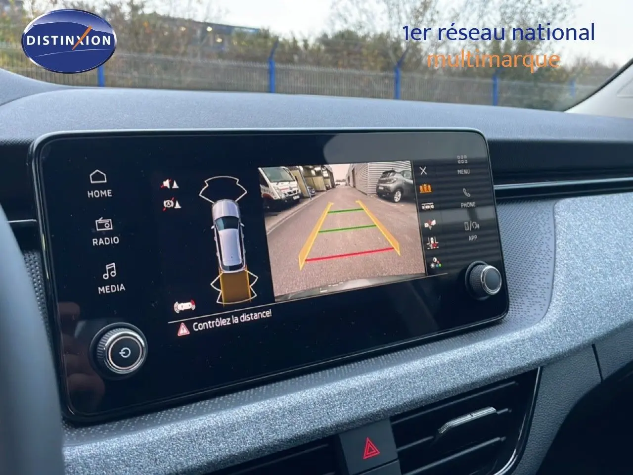 Écran tactile intérieur du Skoda Kamiq 2025 montrant la caméra de recul avec guidage couleur sur fond gris graphite métal.