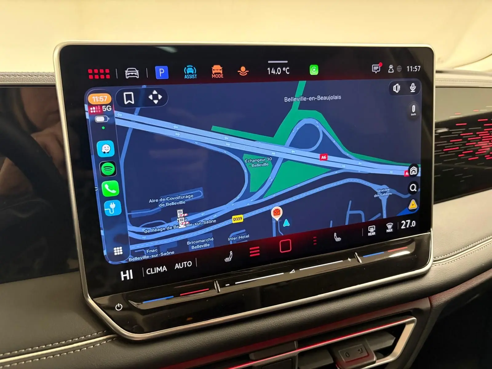 Écran tactile central du Volkswagen Tiguan 2025 affichant la navigation, avec tableau de bord noir et surpiqûres blanches.