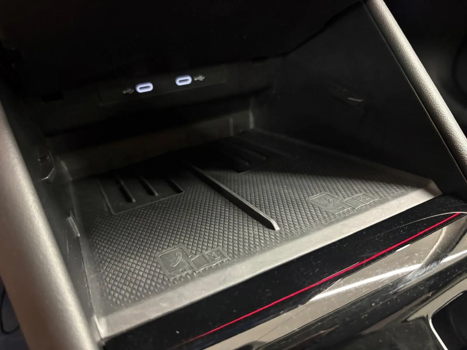 Gros plan sur la zone de recharge sans fil noire avec deux ports USB-C éclairés dans le Volkswagen Tiguan 2025.