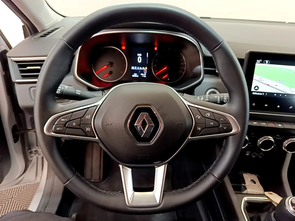 Vue intérieure centrée sur le volant noir de la Renault Clio Business TCe 100 avec tableau de bord et écran tactile visible.